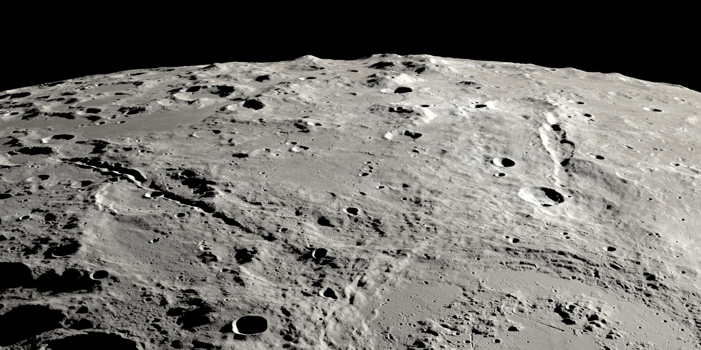 This image provided by NASA shows a view from orbit looking obliquely across the surface of the moon, where an ancient asteroid strike carved out a pair of grand canyons on the moon’s far side. (Ernie T. Wright/NASA via AP)