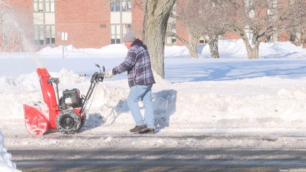 A workers clearing the sidewalk near a school. (WJAR)