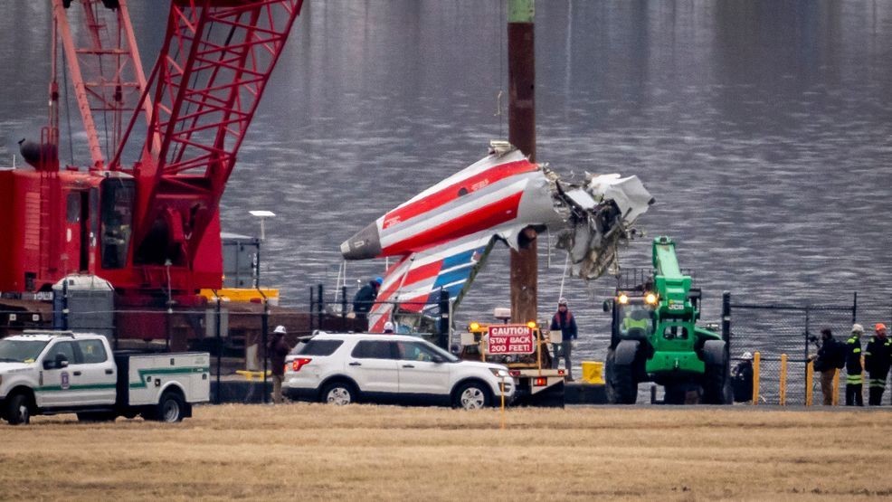 FILE - A crane offloads a piece of wreckage from a salvage vessel onto a flatbed truck, near the wreckage site in the Potomac River of a mid-air collision between an American Airlines jet and a Black Hawk helicopter, at Ronald Reagan Washington National Airport, Feb. 5, 2025, in Arlington, Va. (AP Photo/Ben Curtis, File)